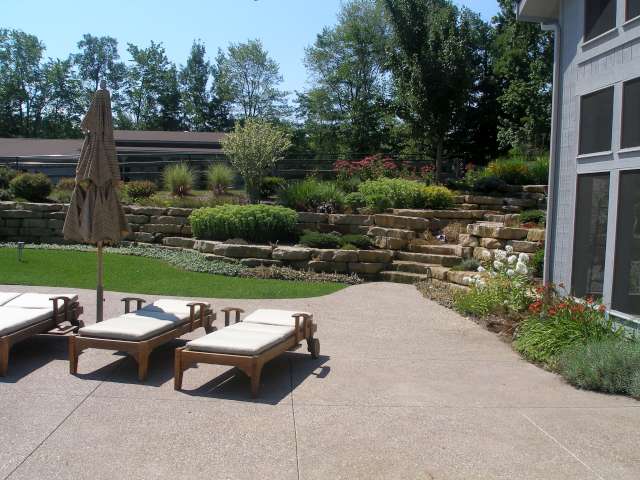 Solon Ohio home showing patio and hillside landscape designed with natural stone retaining walls